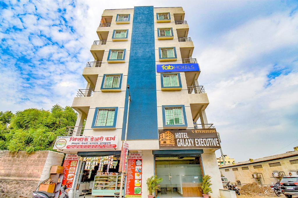 a tall building with a blue facade at FabHotel Galaxy Inn in Pune