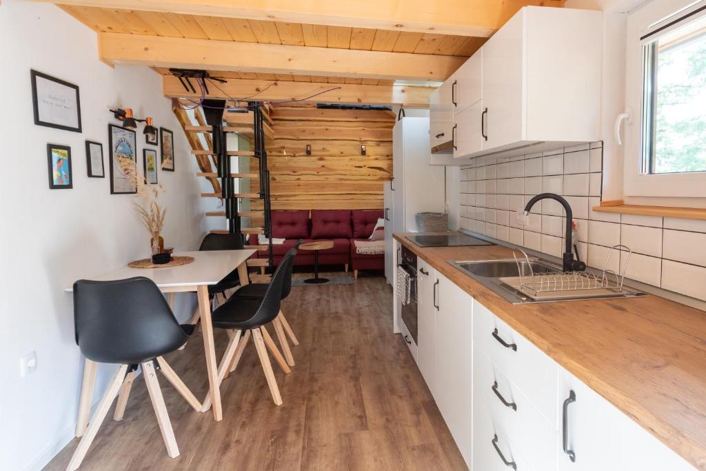 a kitchen with white cabinets and a table and chairs at Lavender Lodge Bled in Bled