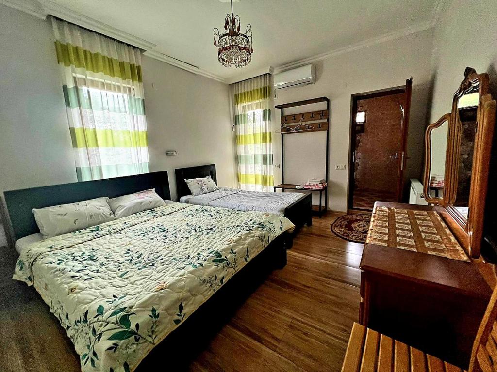 1 dormitorio con 1 cama grande y espejo en Four Seasons in Kutaisi en Kutaisi