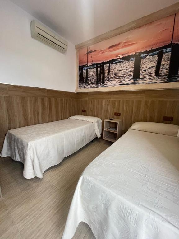 Łóżko lub łóżka w pokoju w obiekcie Hostal Noli