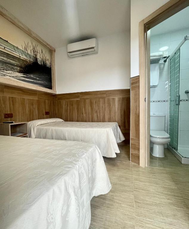 Łóżko lub łóżka w pokoju w obiekcie Hostal Noli