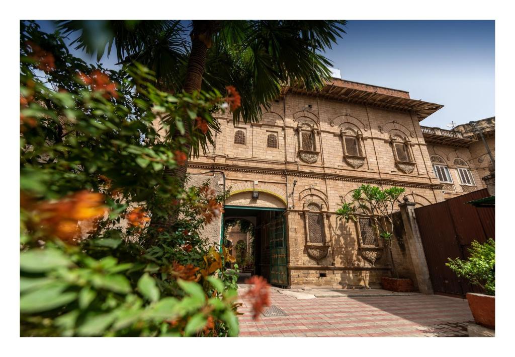 an old building with a palm tree in front of it at Krishnayan Heritage in Gwalior