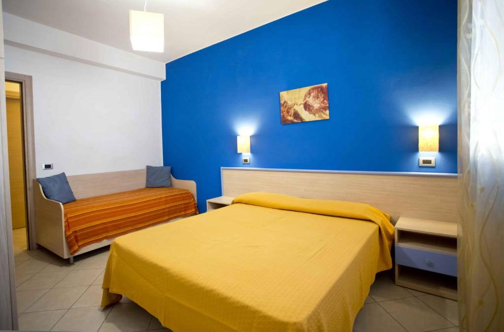 a hotel room with two beds and a blue wall at Terra del Sole in Favignana