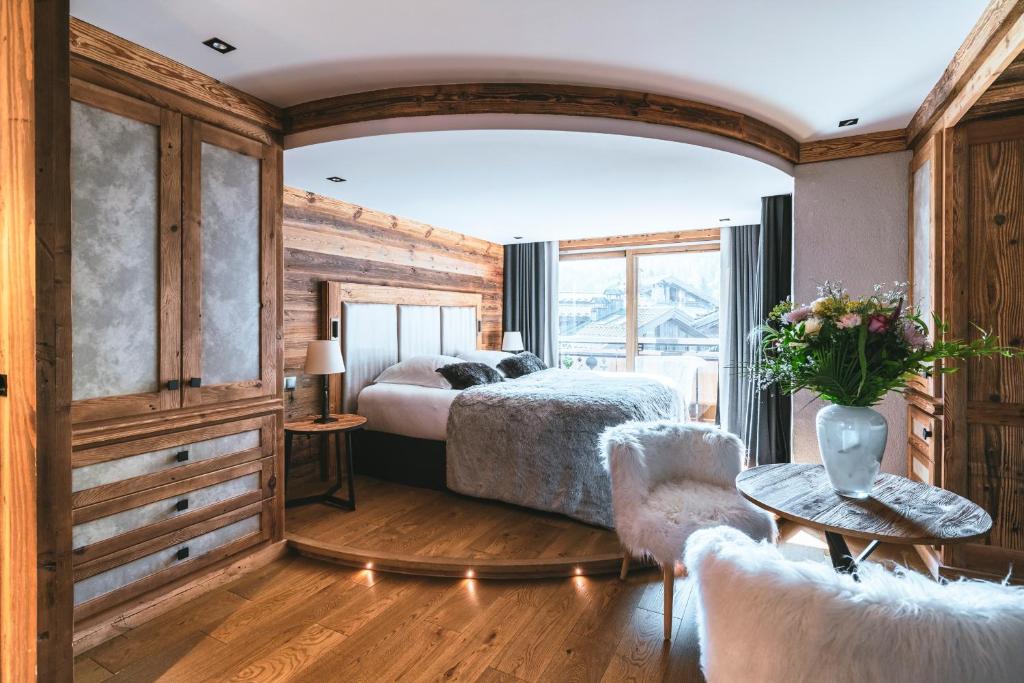 1 dormitorio con cama y ventana grande en Les Peupliers en Courchevel