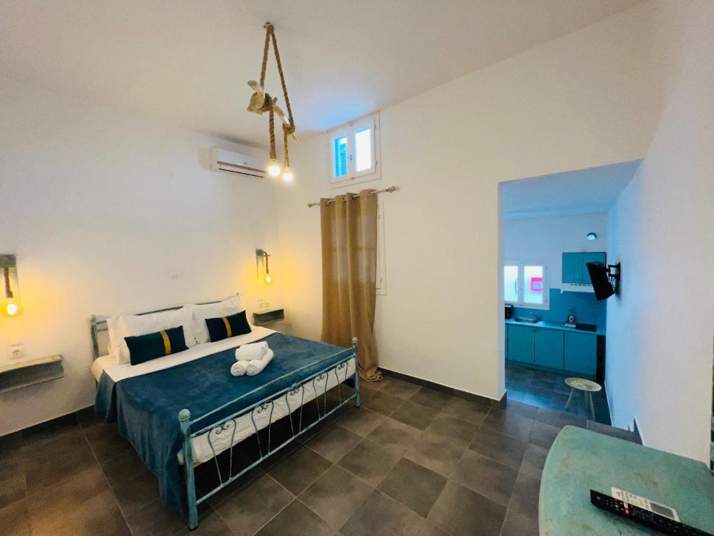 a bedroom with a bed with a blue comforter at Family Villages Santorini in Vlychada Beach