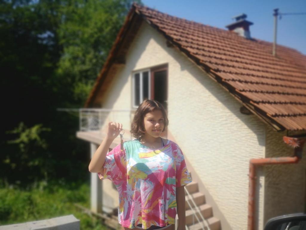 Eine Frau, die vor einem Haus steht. in der Unterkunft Small house in Celje in Celje