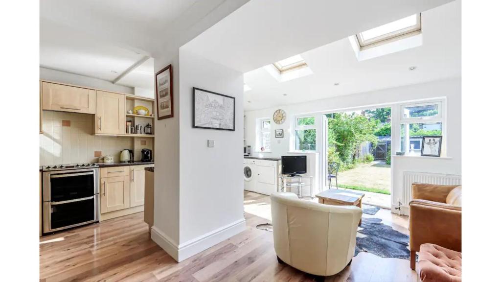 eine Küche mit weißen Schränken und ein Wohnzimmer in der Unterkunft Pass the Keys Lovely 3 Bedroom Garden Home in Oxford in Oxford