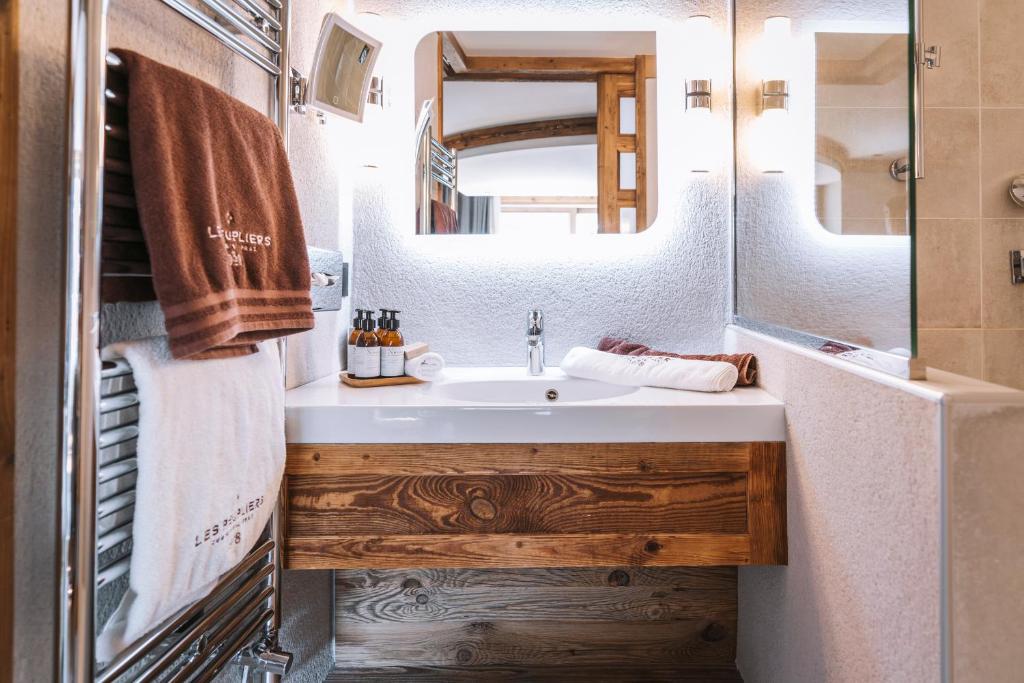 a bathroom with a sink and a mirror at Hôtel Les Peupliers in Courchevel