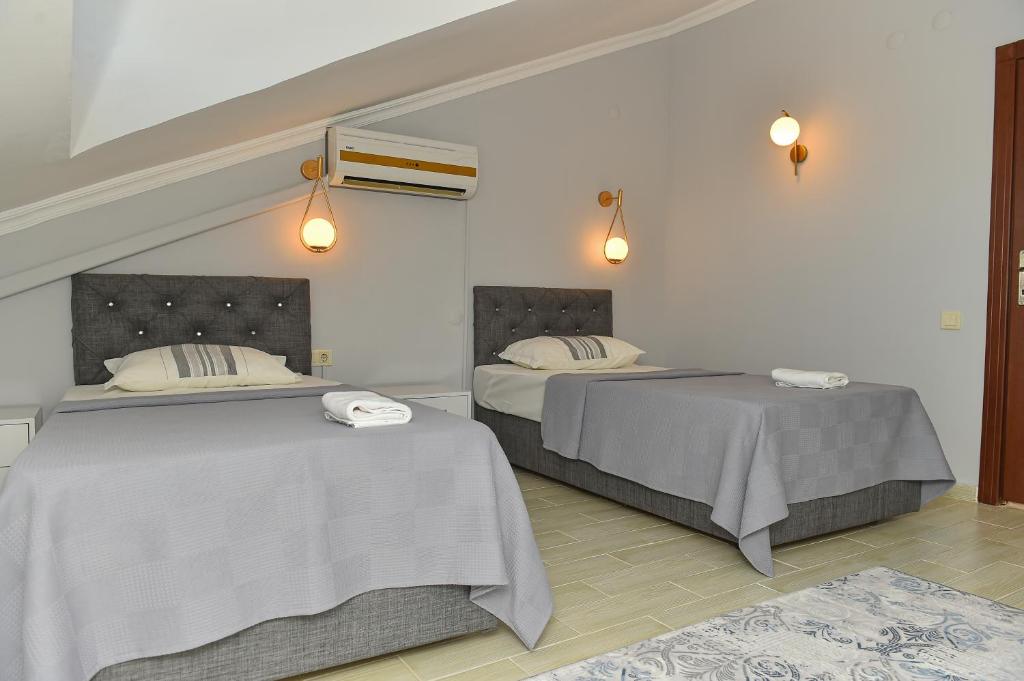 two beds sitting next to each other in a room at VİLLA ALP'S TRİPLEX LAGOON HAVUZ OLANAĞI SUNAN in Belek