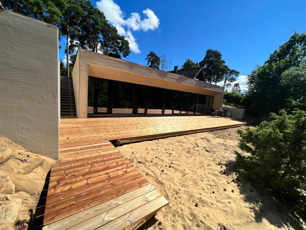 uma casa numa praia com um deque de madeira em Dream Corner Nordic em Laulasmaa