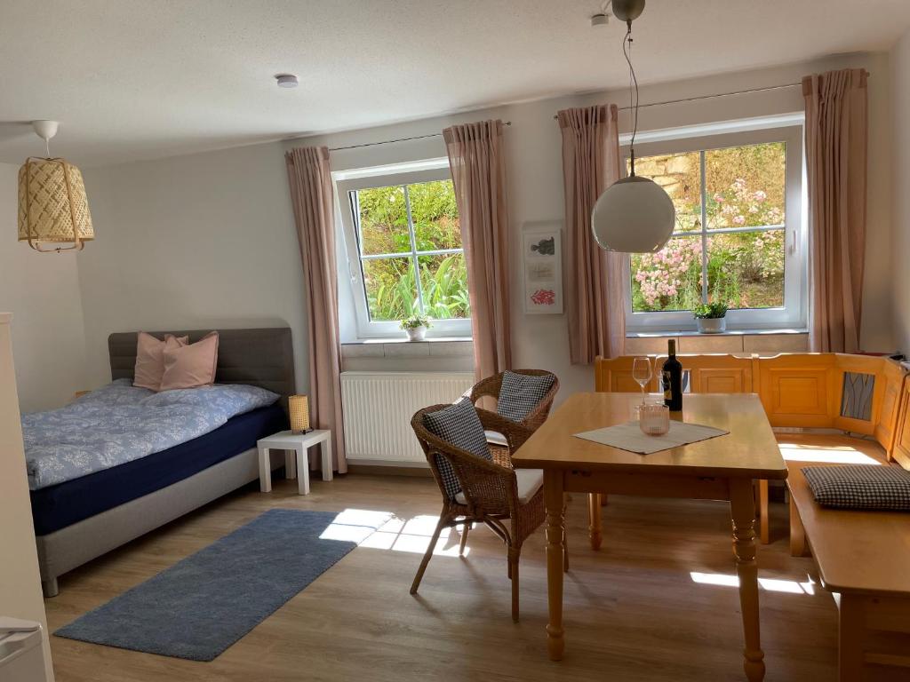 OberhausenにあるSchöne Wohnung mit Pool und Sauna zum Wohlfühlenの小さな客室で、ダイニングテーブル、ベッドルーム1室が備わります。
