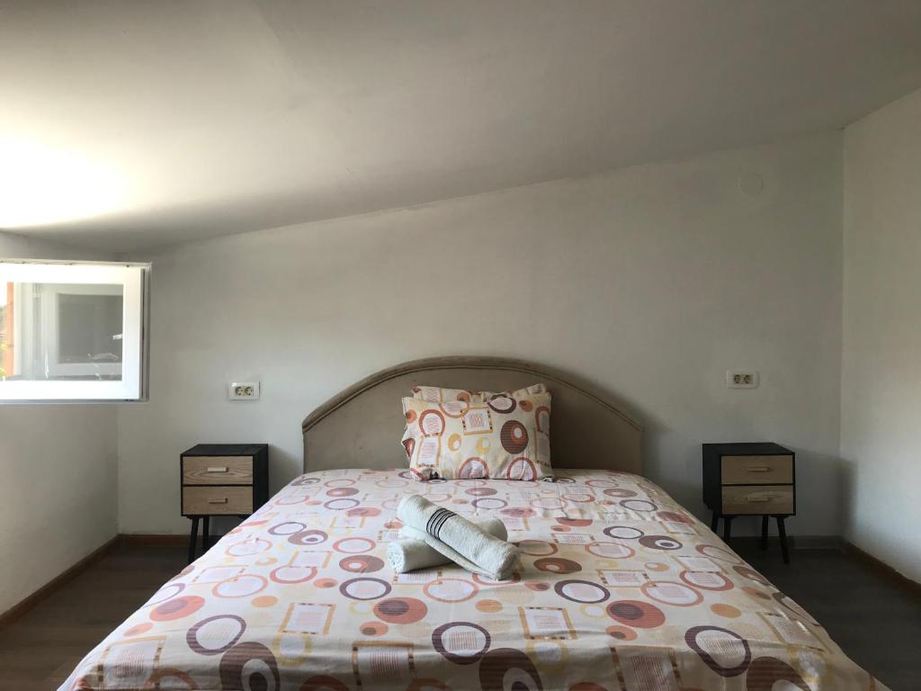 1 dormitorio con 1 cama y 2 mesitas de noche en Apartments OldTown, en Podgorica