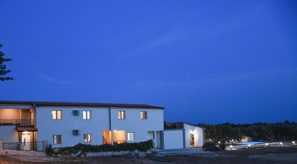 a large white building with lights on at night at Apartments Olea in Biograd na Moru
