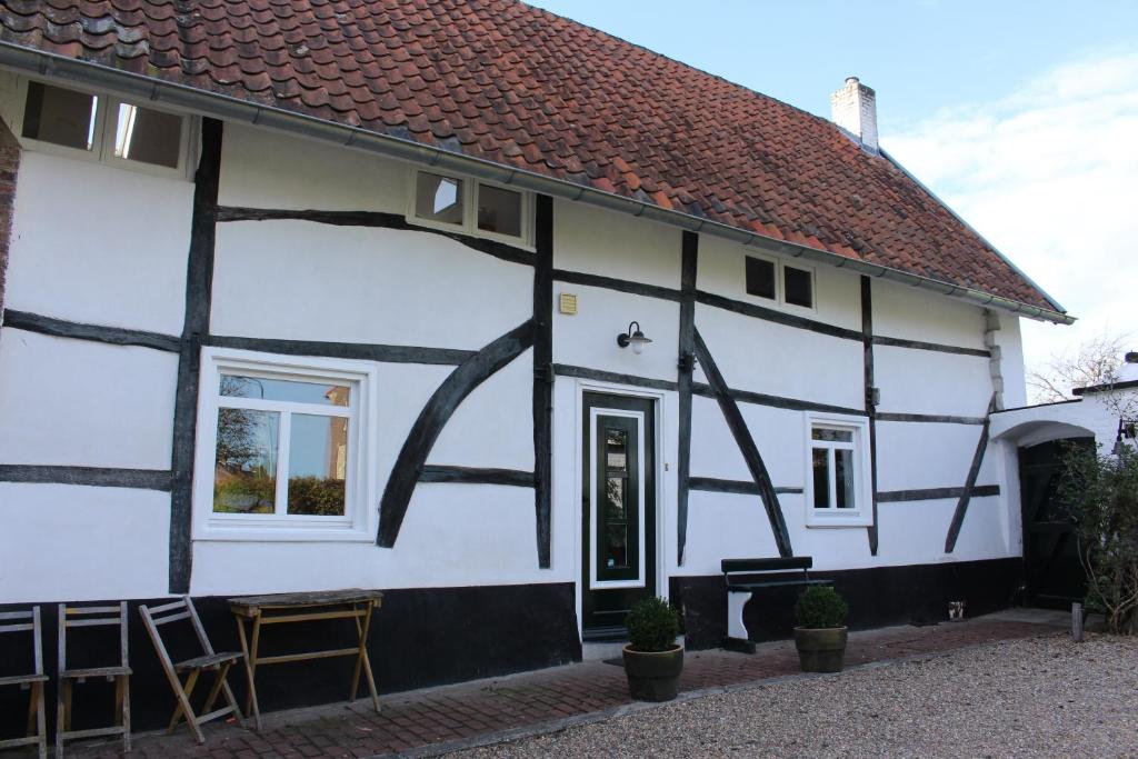 a white and black house with a red roof at Vakwerkvakantiehuis Eckelmus in Eckelrade