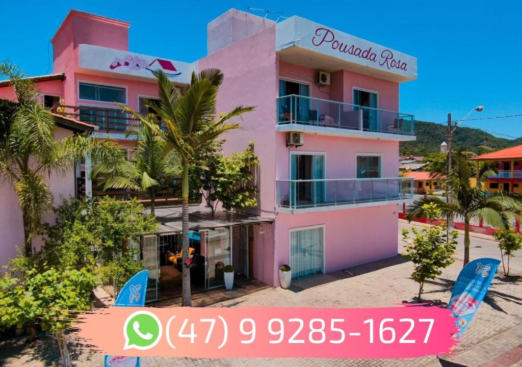 a pink building with blue surfboards in front of it at Pousada Rosa in Penha