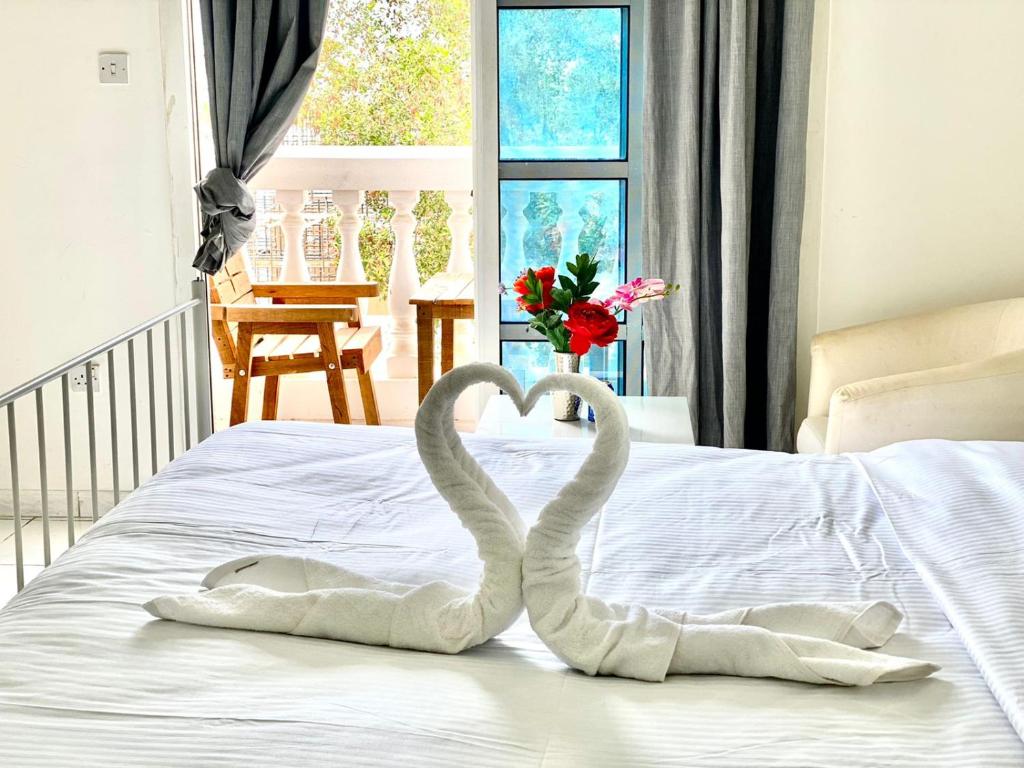 two swans making a heart on a bed at Comfortable Private Rooms in Compound Housing in Dubai