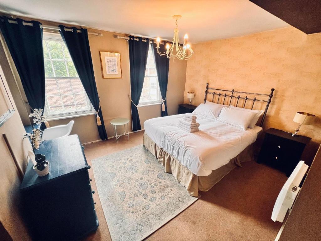 a bedroom with a large bed and a chandelier at George & Dragon Hotel in Buckinghamshire