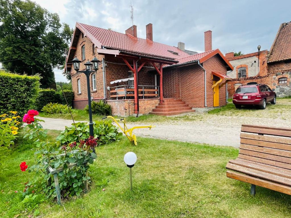 una casa de ladrillo con un coche aparcado delante de ella en Agroturystyka Szerokopaś en Nidzica