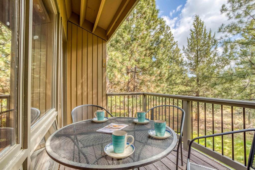 Elle dispose d'un balcon avec une table, des tasses et des chaises. dans l'établissement Ski House 245, à Bend