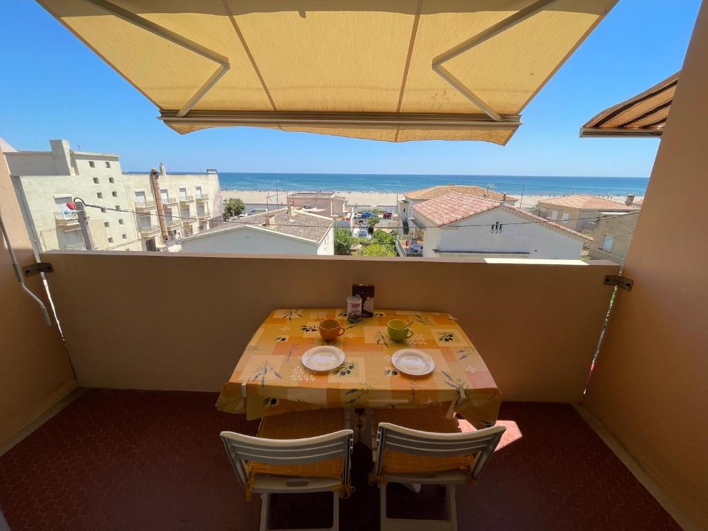 een tafel en stoelen op een balkon met uitzicht bij Appartement T2 Vue sur Mer Narbonne Plage- 5CAPA31 in Narbonne-Plage