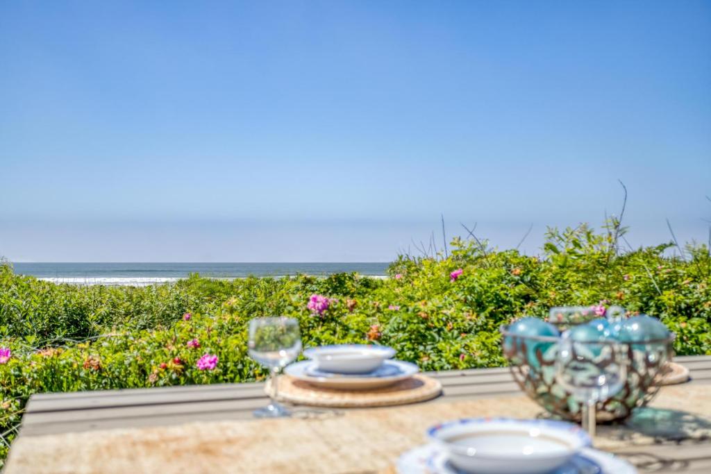 a table with plates and glasses and a view of the ocean at Sandpiper Retreat in Waldport
