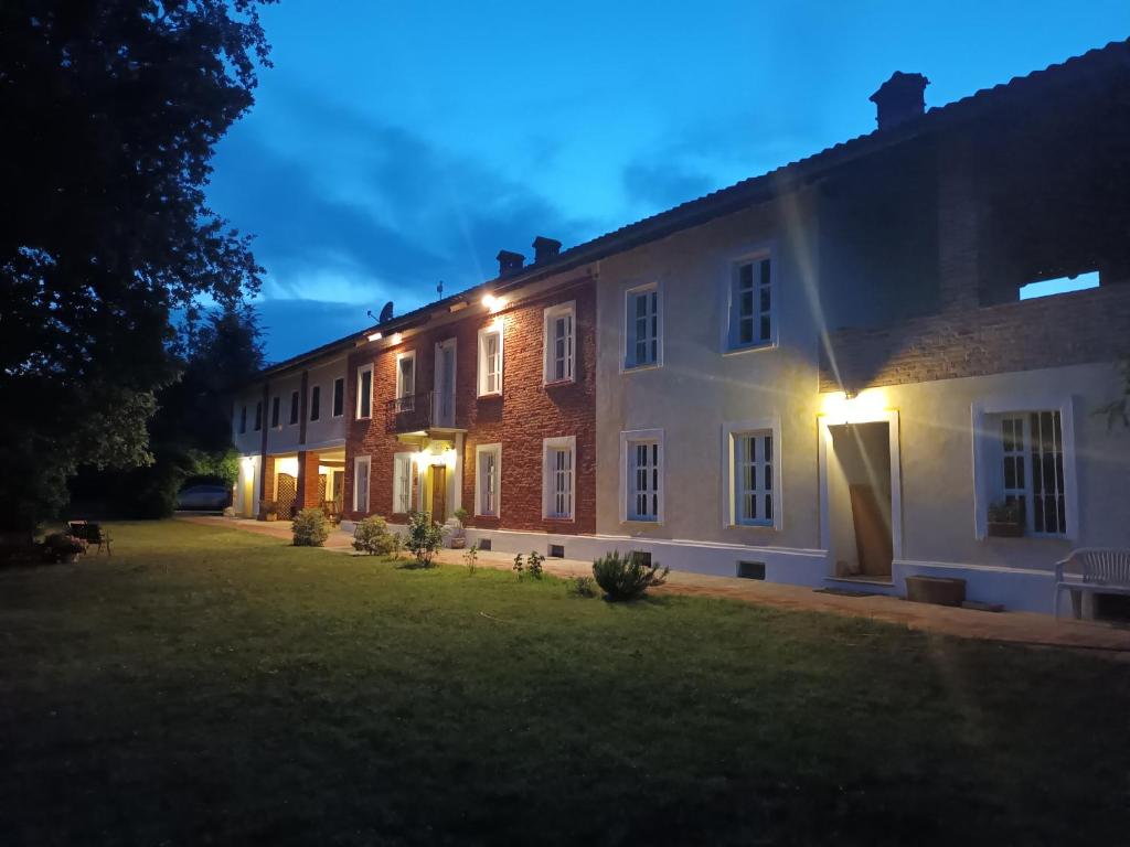 un grande edificio in mattoni con luci sul lato di Guest House La Carolina a Tigliole