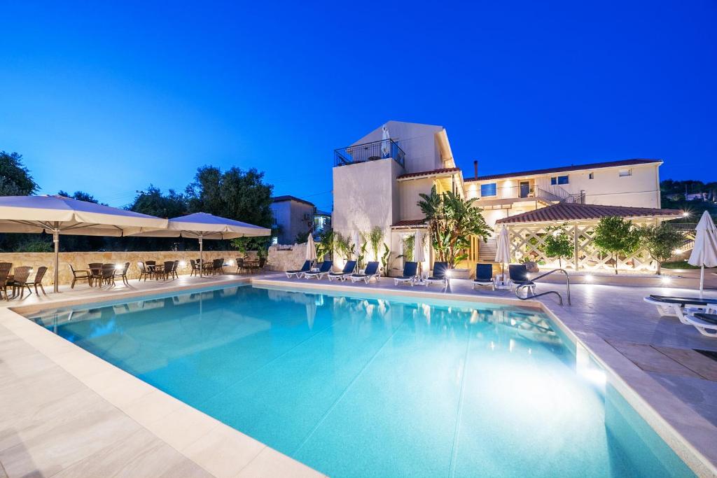 a swimming pool in front of a building at Makris Yialos Apartments in Lassi