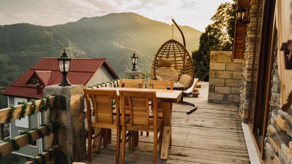 um deque de madeira com uma mesa e cadeiras numa varanda em Orca Bungalows em Ardeşen