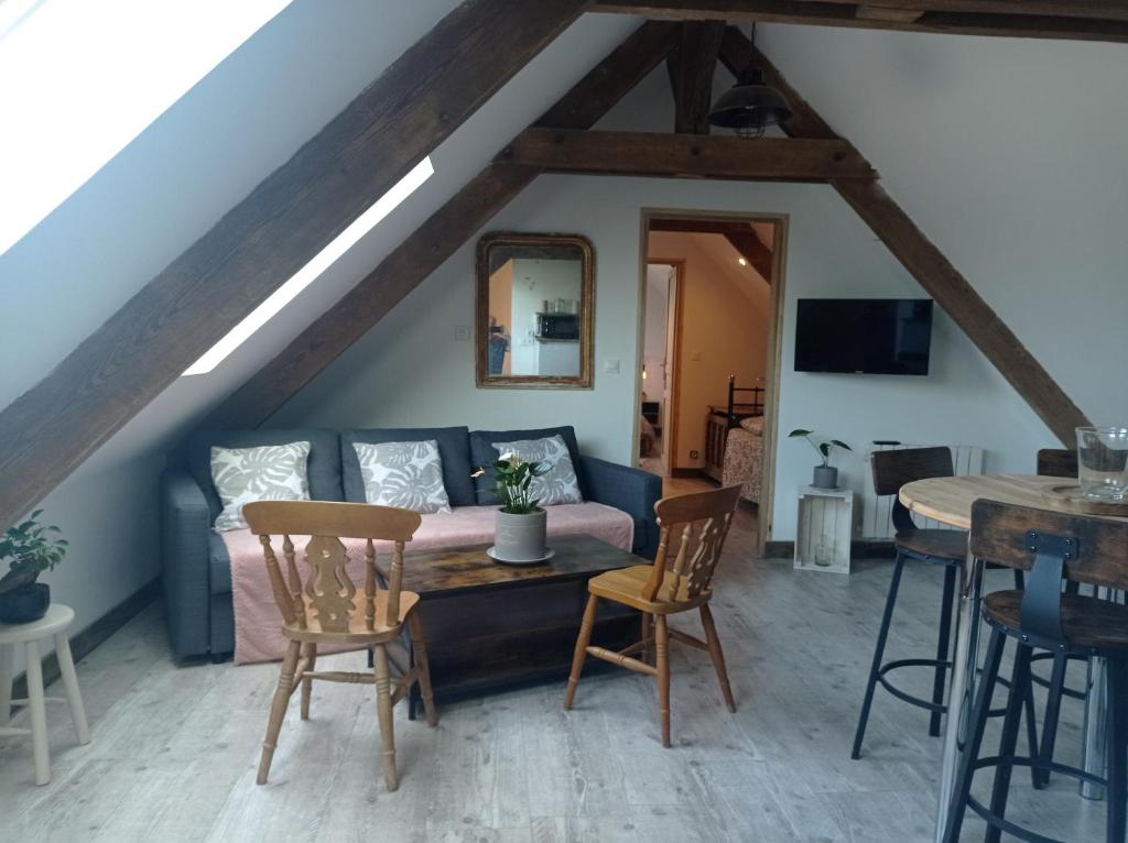 een woonkamer met een bank en een tafel bij Maris Domus près des plages du débarquement in Bayeux