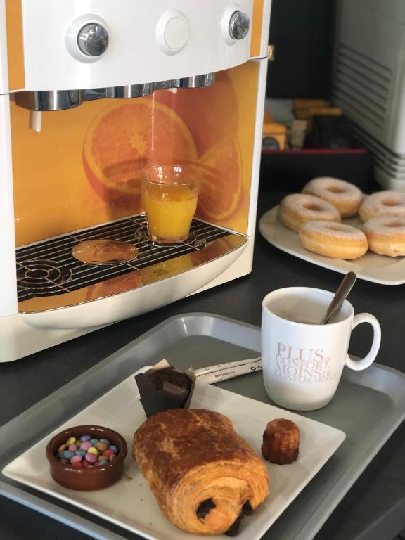 a plate of doughnuts and a cup of coffee and a mixer at Kyriad Montpellier Aéroport - Gare Sud de France in Mauguio