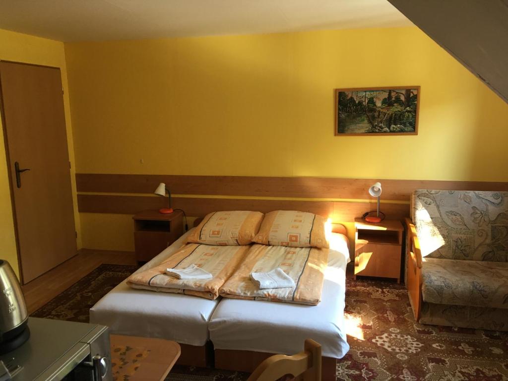 a hotel room with two beds and a chair at Chalupa pod lipami in Terchová