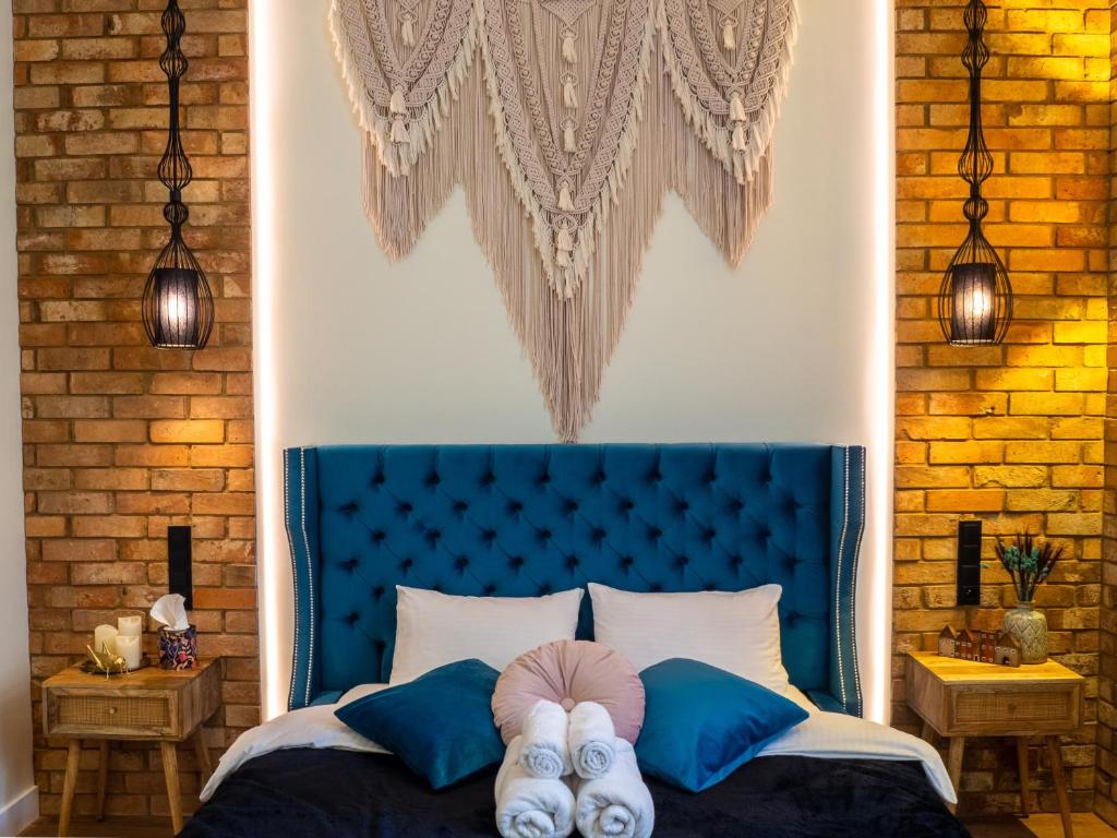 sypialnia z niebieskim łóżkiem, na której leżą dwie osoby w obiekcie Brick Castle - Apartament Ulrich we Wrocławiu