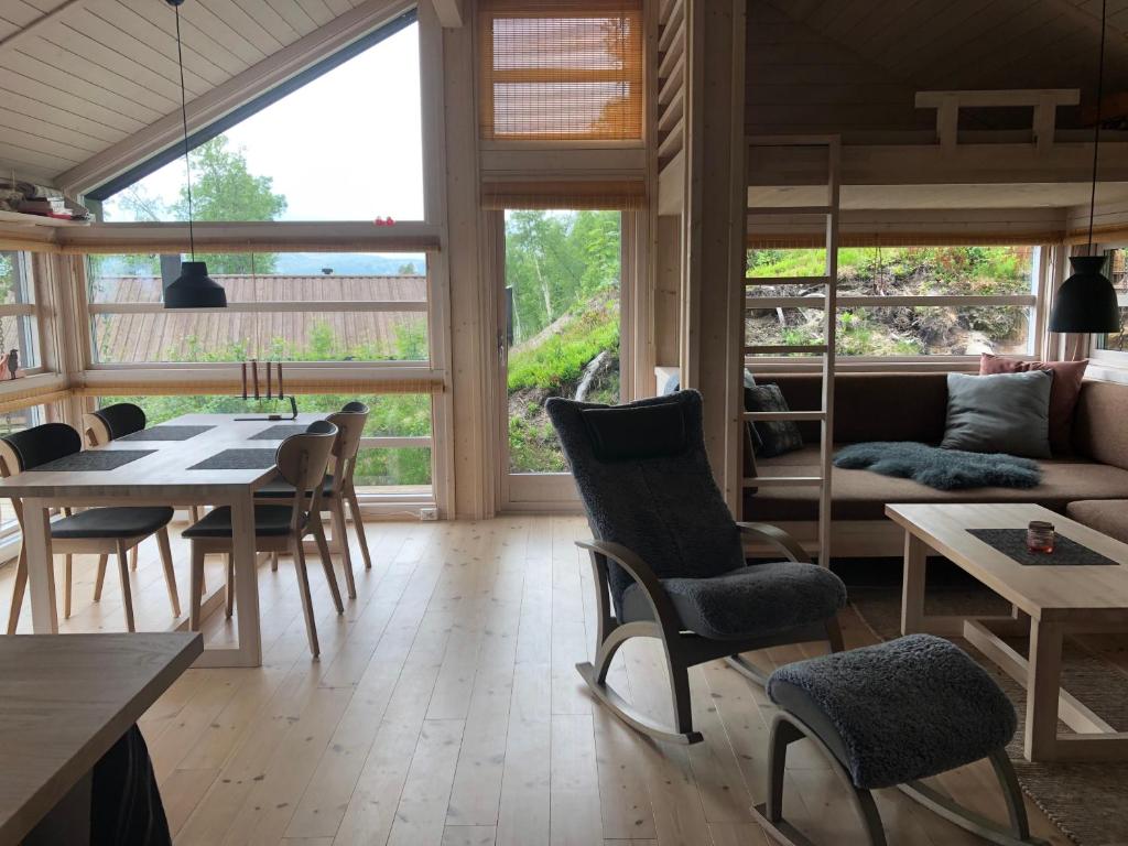 sala de estar con sofá, mesa y sillas en Hytte på Sørbølfjellet en Flå