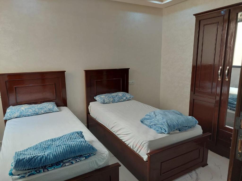 two beds in a small room at Nador hay al Matar in Nador
