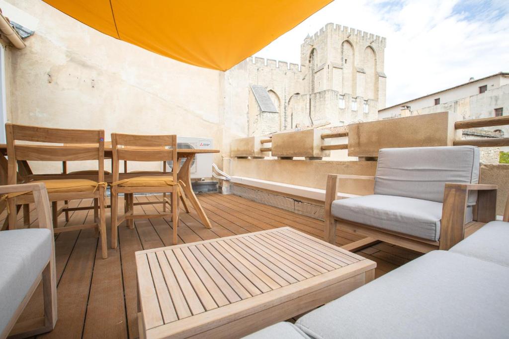 een balkon met stoelen en een tafel in een gebouw bij La Terrasse du Palais in Avignon