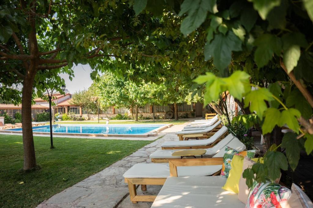 a row of chaise lounges next to a pool at Mogla Tashan Hotel in Muğla