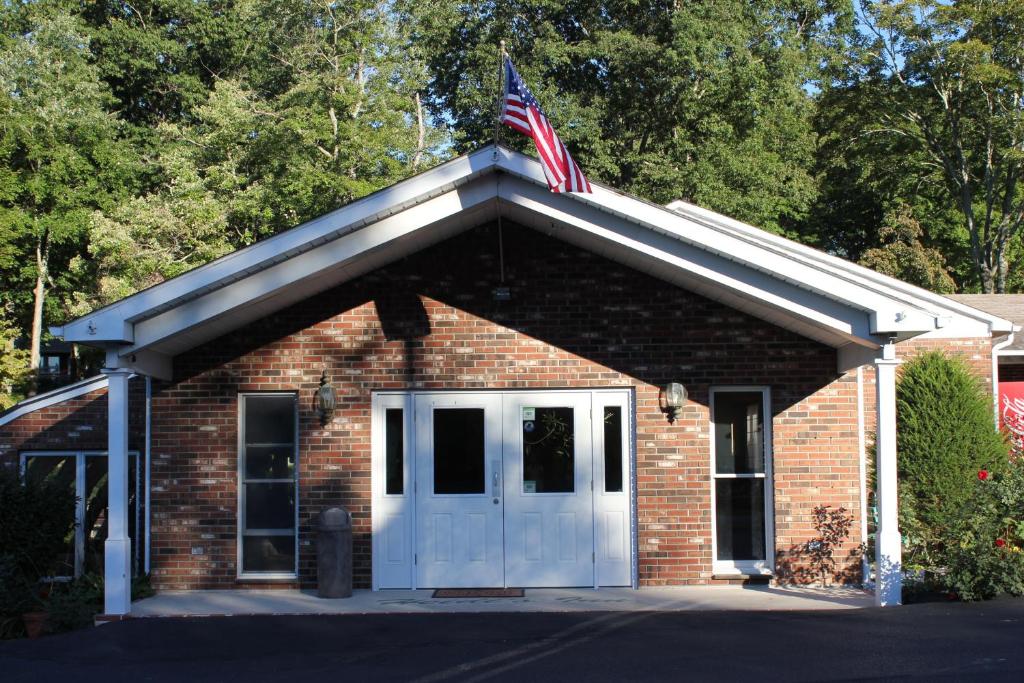 a small brick building with an american flag on top at Heidi's Inn in Brewster