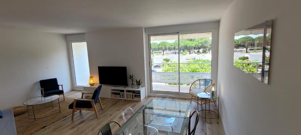 a living room with a glass table and chairs at Superbe appartement Arcachon in La Teste-de-Buch