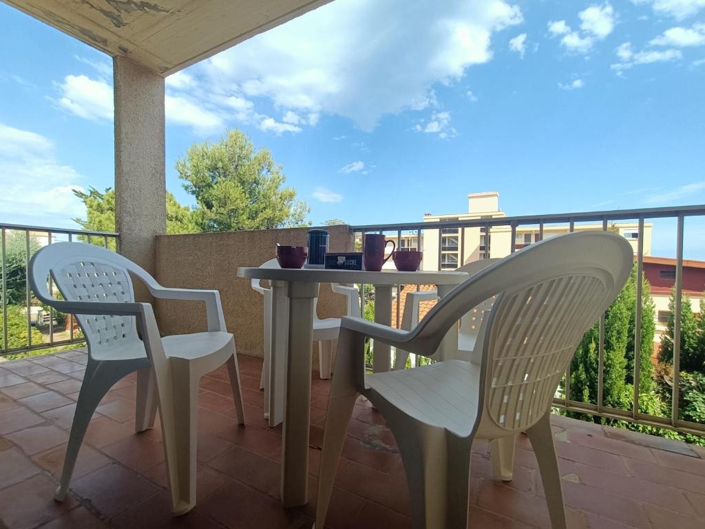 weranda ze stołem i krzesłami na balkonie w obiekcie Appartement pour 4 personnes à 50m de la plage Narbonne Plage 4LP2A8 w mieście Narbonne-Plage