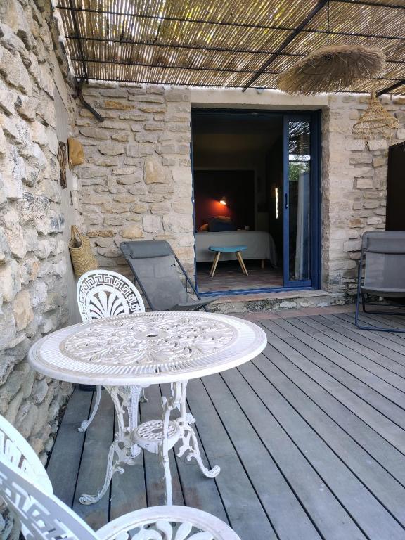 a patio with a table and chairs on a wooden deck at chambre d&#39;hôtes Et Puis Voilà! in Murs