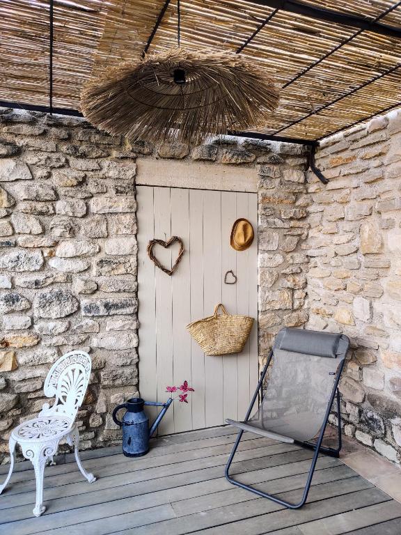 a porch with a chair and a door with a basket at chambre d&#39;hôtes Et Puis Voilà! in Murs