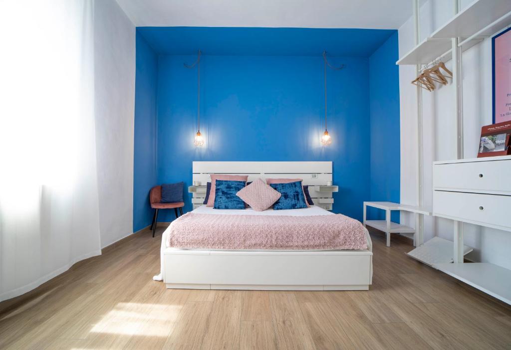 Dormitorio azul con cama y pared azul en Boutique Apartment, en Chiusi