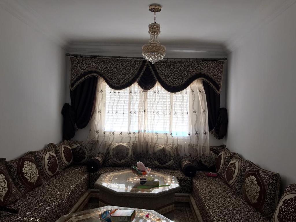 a living room with a couch and a window at bel appartement dans une residence calme in Martil