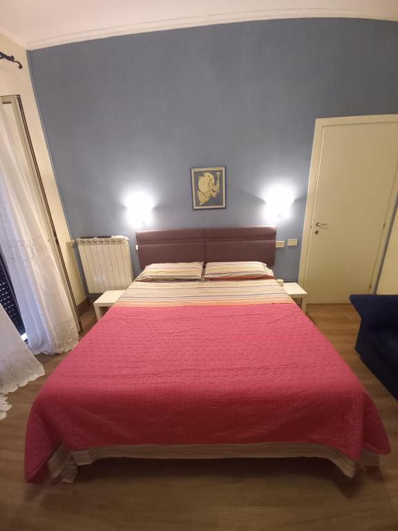 a bedroom with a large bed with a red blanket at Minisuite in Rome in Vitinia