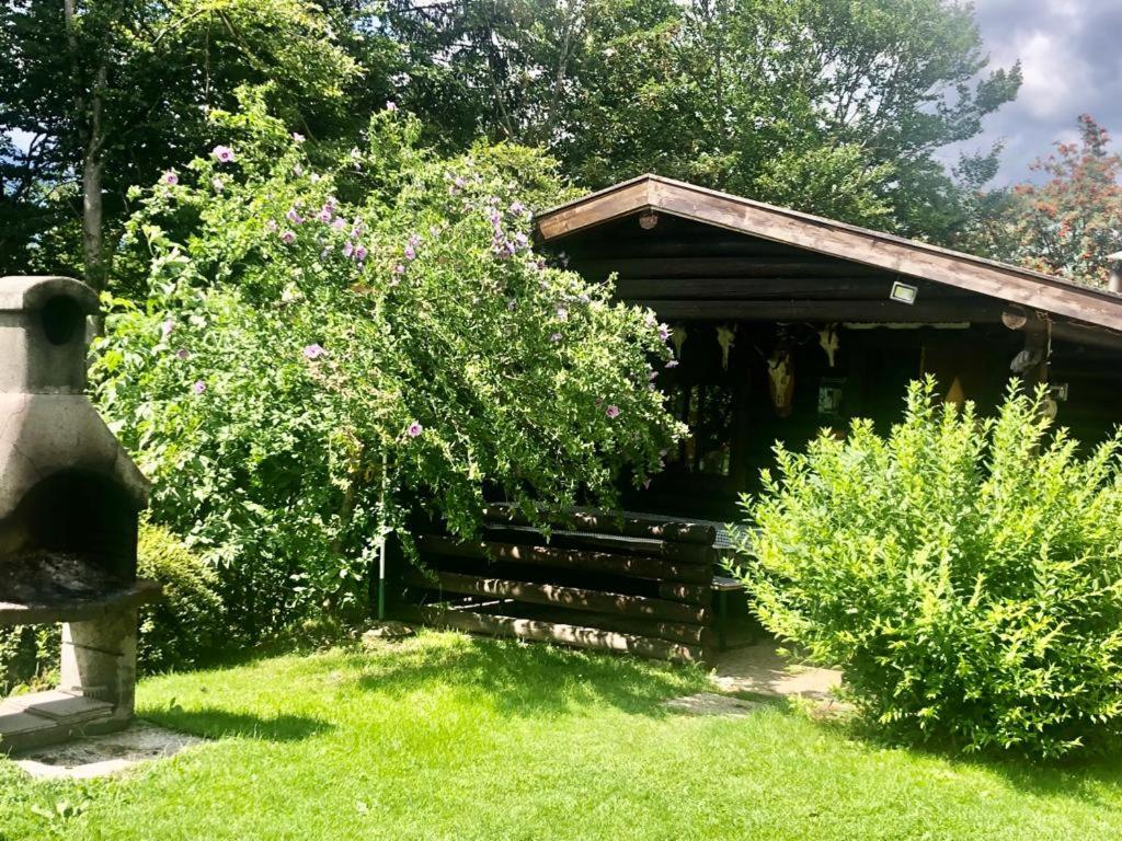 a wooden shelter with a bench in the grass at Ferienwohnung Kendlbacher in Bischofshofen