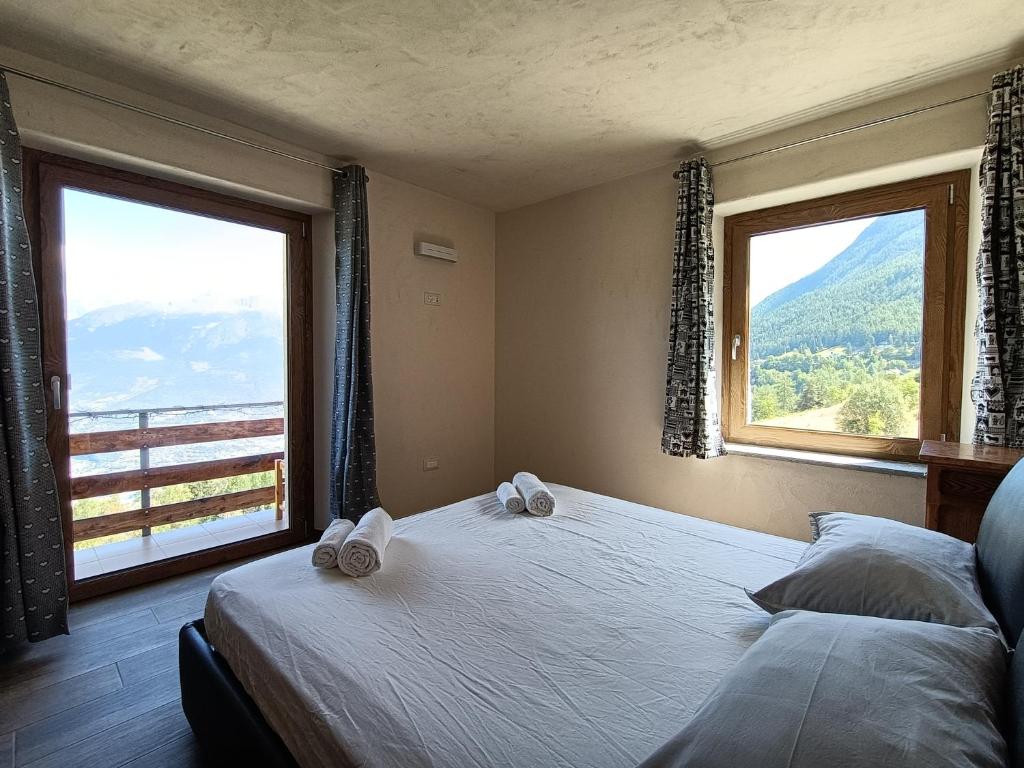 a bedroom with two beds and a large window at Les Flocons Pila in Pila