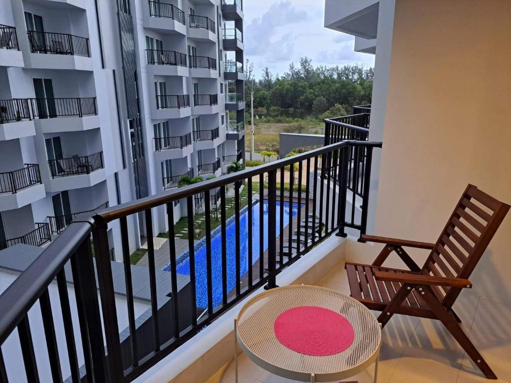 a balcony with a table and a chair and a pool at Mantra Holiday Home in Mae Pim