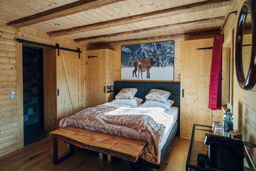 1 dormitorio en una cabaña de madera con 1 cama y 1 mesa en Alpen Lodge Berwang, en Berwang