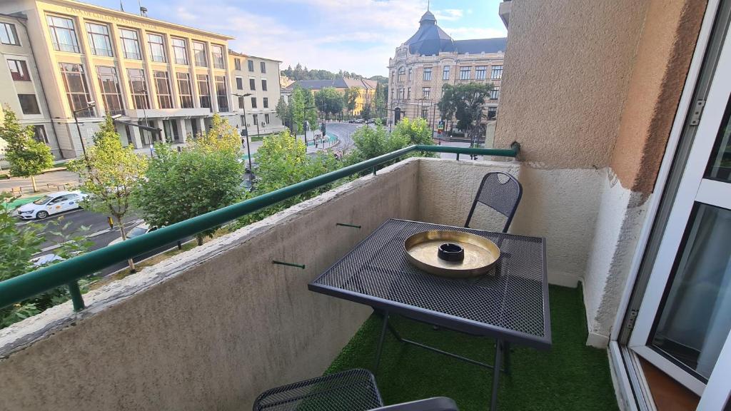 un balcón con una mesa y un tazón. en Main square 5 star luxury apartment with view, en Cluj-Napoca