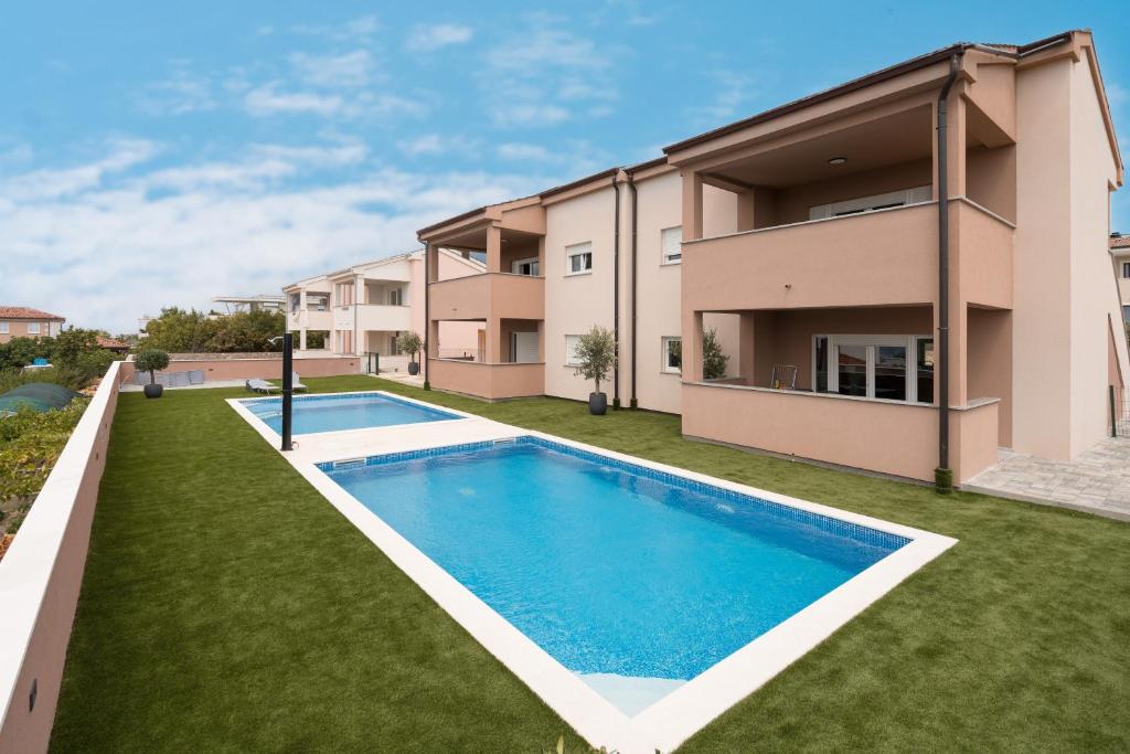 Linardići的住宿－Apartmani Villa Ruby，房屋前游泳池的图像